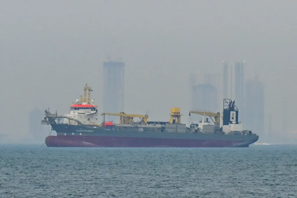 An oil tanker in the Strait of Hormuz — the waterway's closure following US-Israeli strikes on Iran triggered an energy shock that the IMF projects will cut global growth by up to 0.3 percentage points under its reference scenario