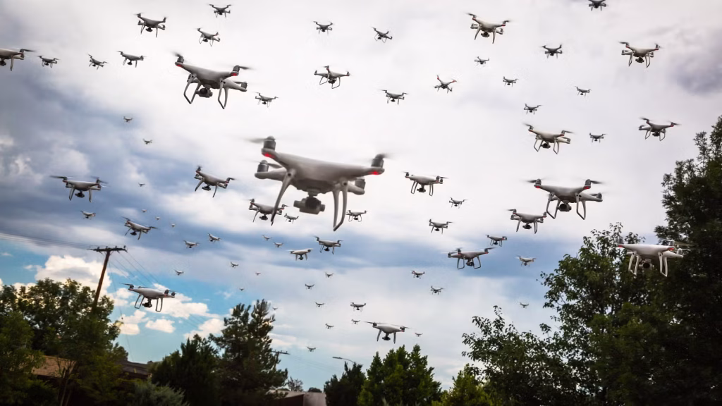 An autonomous military drone swarm in coordinated operation — the first multi-manufacturer combat drone swarm was demonstrated in December 2025, with a single operator commanding multiple drone types simultaneously